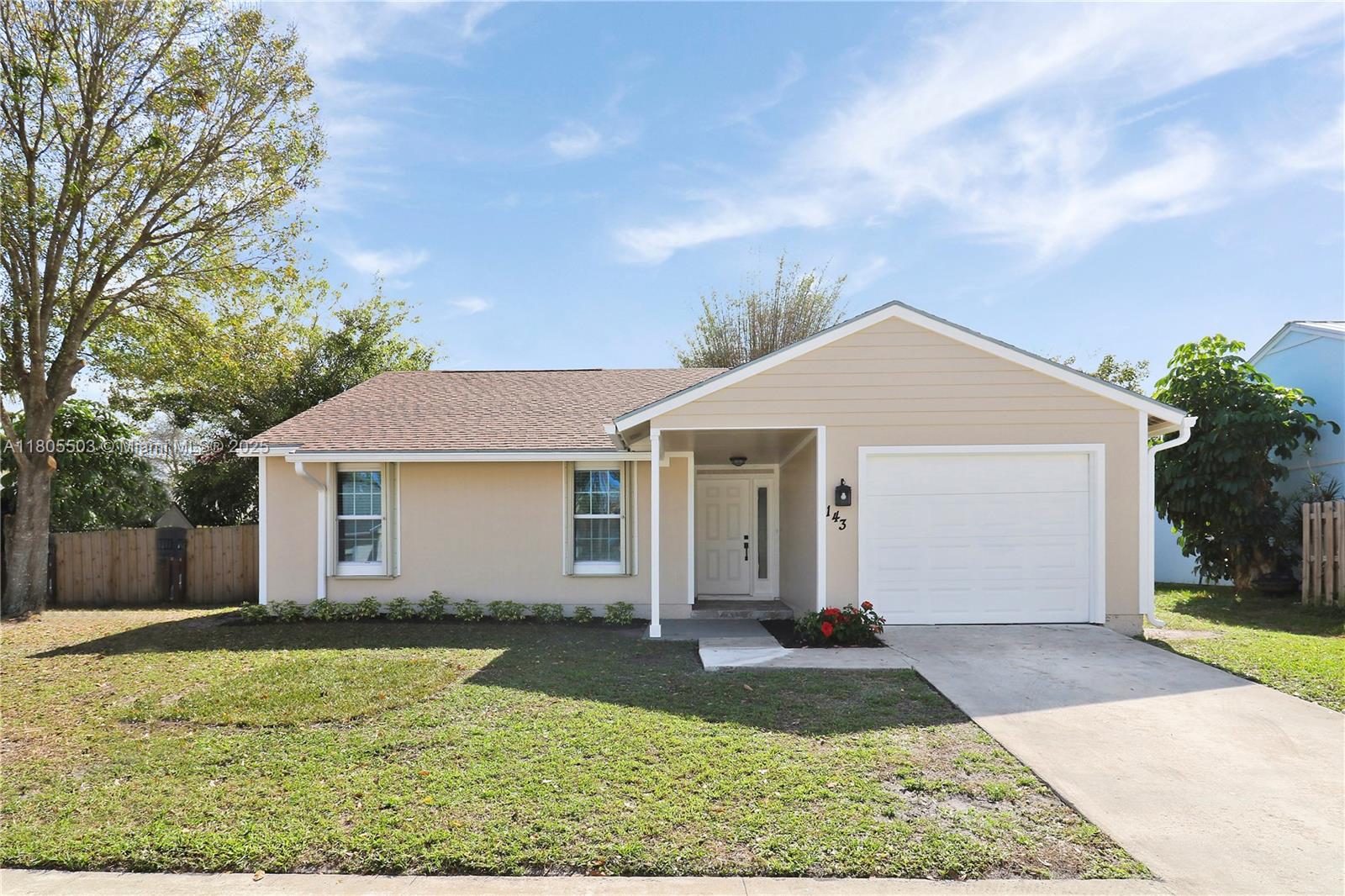 143 Greentree Circle Jupiter, FL 33458 - Photo 2 of 16 front view of a house and a yard