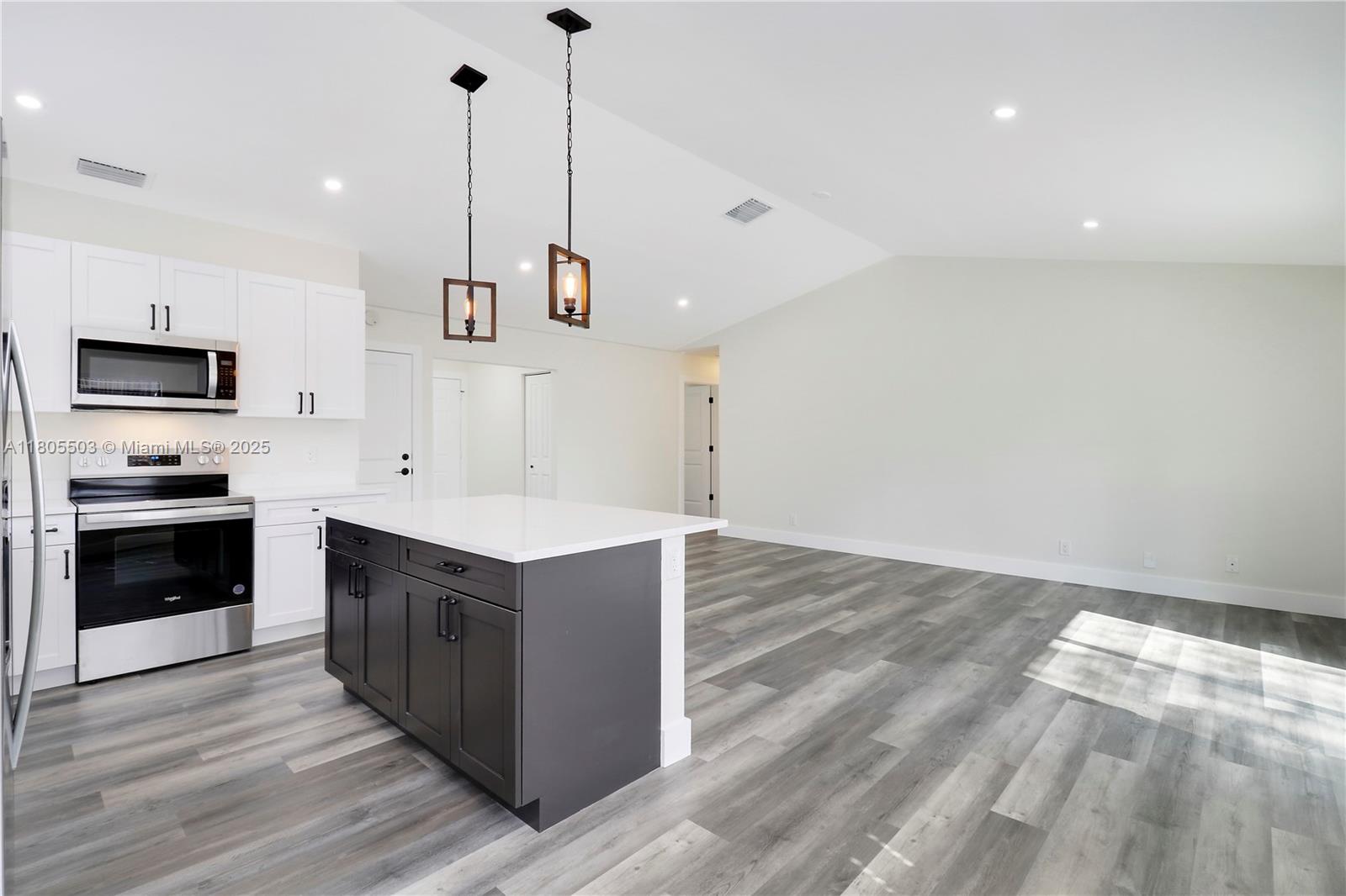 143 Greentree Circle Jupiter, FL 33458 - Photo 8 of 16 a kitchen with a stove and a wooden floor
