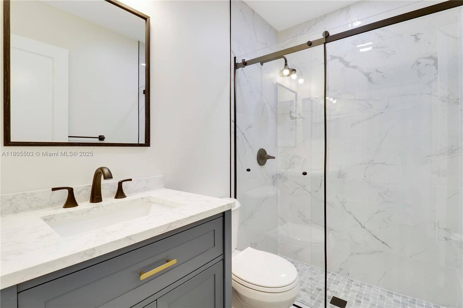 143 Greentree Circle Jupiter, FL 33458 - Photo 10 of 16 a bathroom with a sink a mirror a toilet and shower