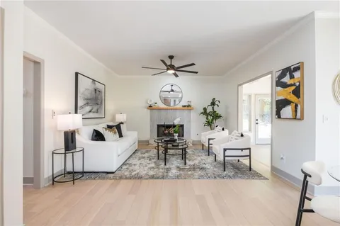 a living room with furniture a fireplace and a chandelier