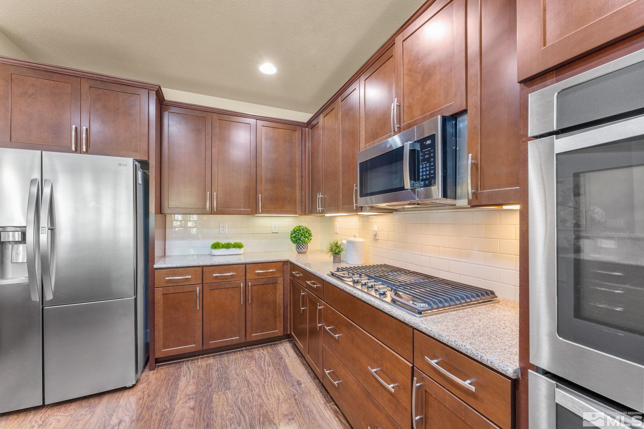 9207 Sassafras Trail Reno, NV 89523 - Photo 20 of 40 a kitchen with stainless steel appliances granite countertop a refrigerator a sink and wooden cabinets