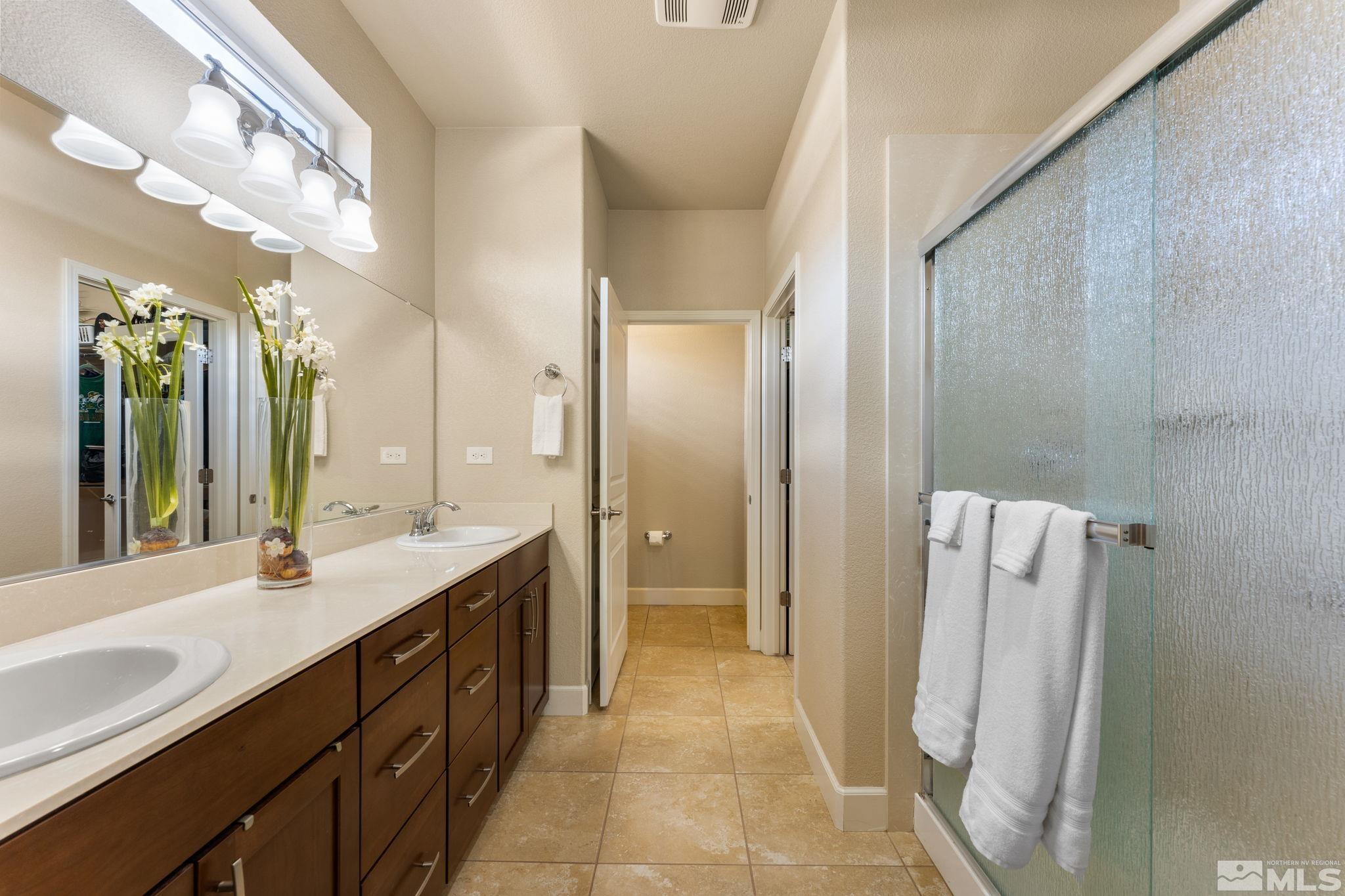9207 Sassafras Trail Reno, NV 89523 - Photo 26 of 40 a spacious bathroom with a double vanity sink a mirror and a shower