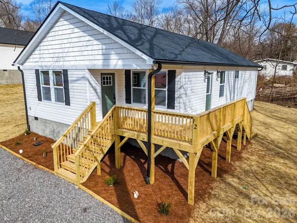 a view of a house with wooden deck and furniture
