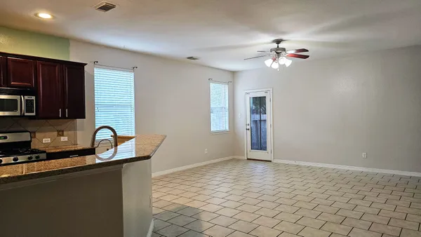 a kitchen with granite countertop a stove a sink and a microwave