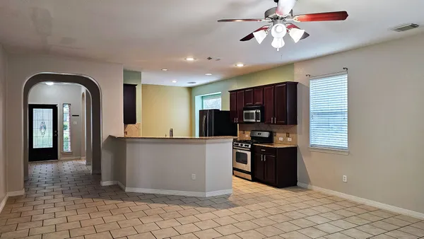 a kitchen with stainless steel appliances granite countertop a refrigerator a sink a stove top oven and a dishwasher