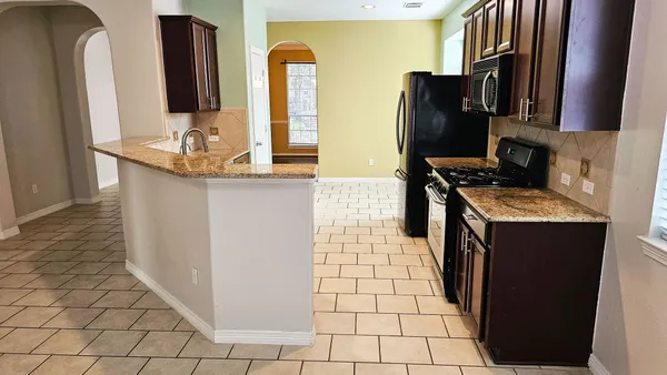 a kitchen with stainless steel appliances granite countertop a refrigerator and a sink