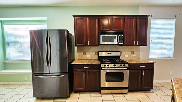 a kitchen with a stove a refrigerator and cabinets