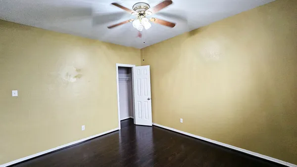 a view of an empty room with wooden floor