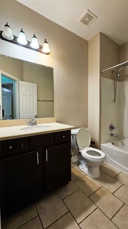 a bathroom with a sink vanity mirror and toilet