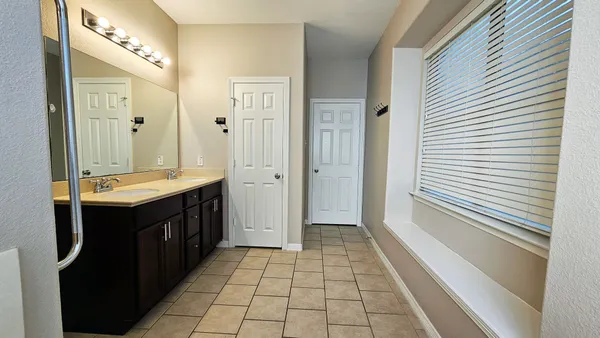 a bathroom with a double vanity sink a mirror and a shower
