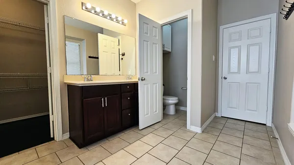 a spacious bathroom with a sink a mirror and a toilet