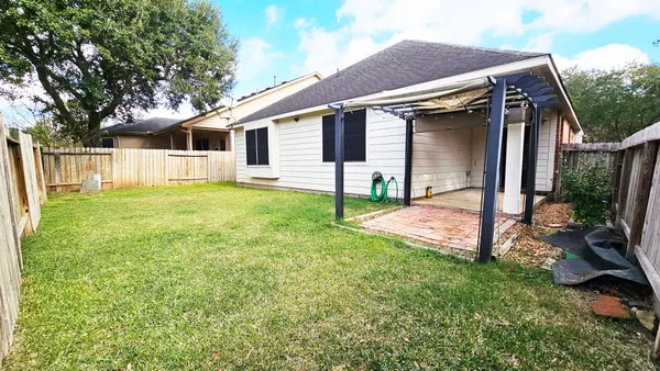 a view of a house with backyard and a tree