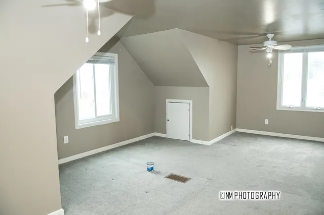 an empty room with windows and painted walls