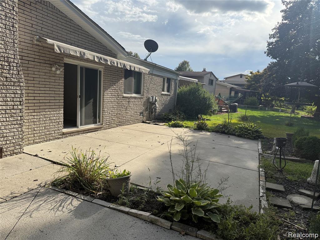 43038 Hanford Road Canton, MI 48187 - Photo 4 of 36 Rear patio featuring concrete surfacing, a brick exterior, and a sliding glass door