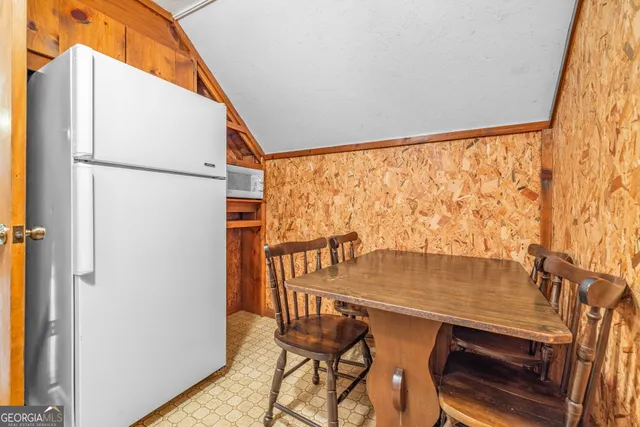a view of an empty room with wooden floor and a ceiling fan