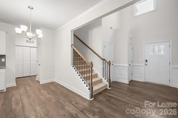 a view of a hallway with wooden floor and staircase