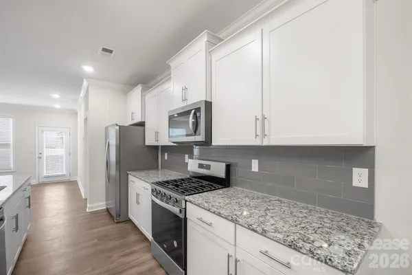 a kitchen with stainless steel appliances granite countertop a stove a refrigerator and a sink