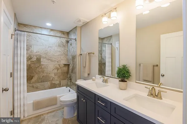 a bathroom with a bathtub shower sink mirror and toilet