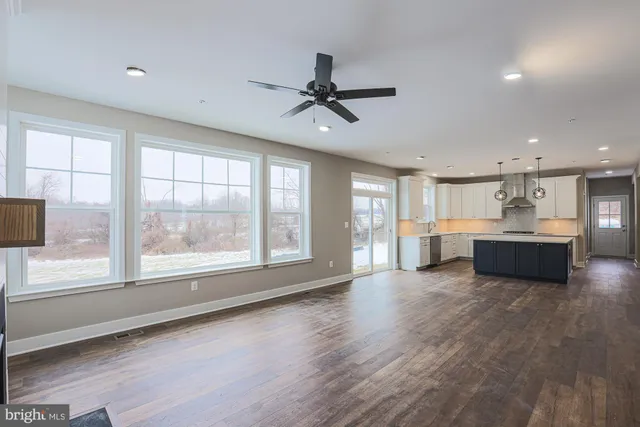 a large kitchen with a lot of counter space and wooden floor