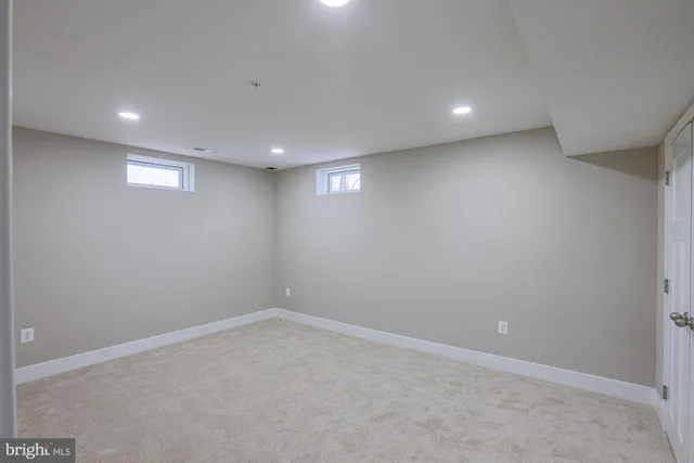an empty room with windows and ceiling fan