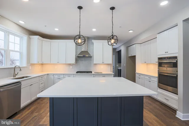 a kitchen with kitchen island a sink stainless steel appliances and cabinets