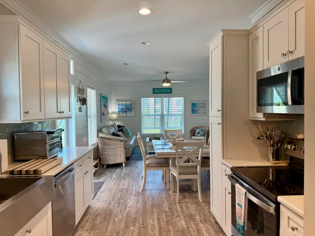 a kitchen with kitchen island granite countertop lots of counter top space a sink stainless steel appliances and cabinets