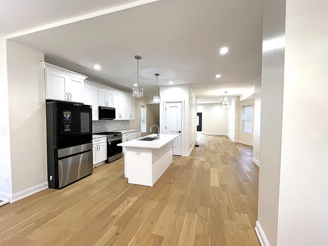 a large kitchen with a sink and a large window