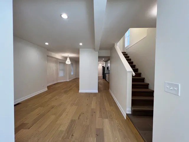a view of empty room with wooden floor
