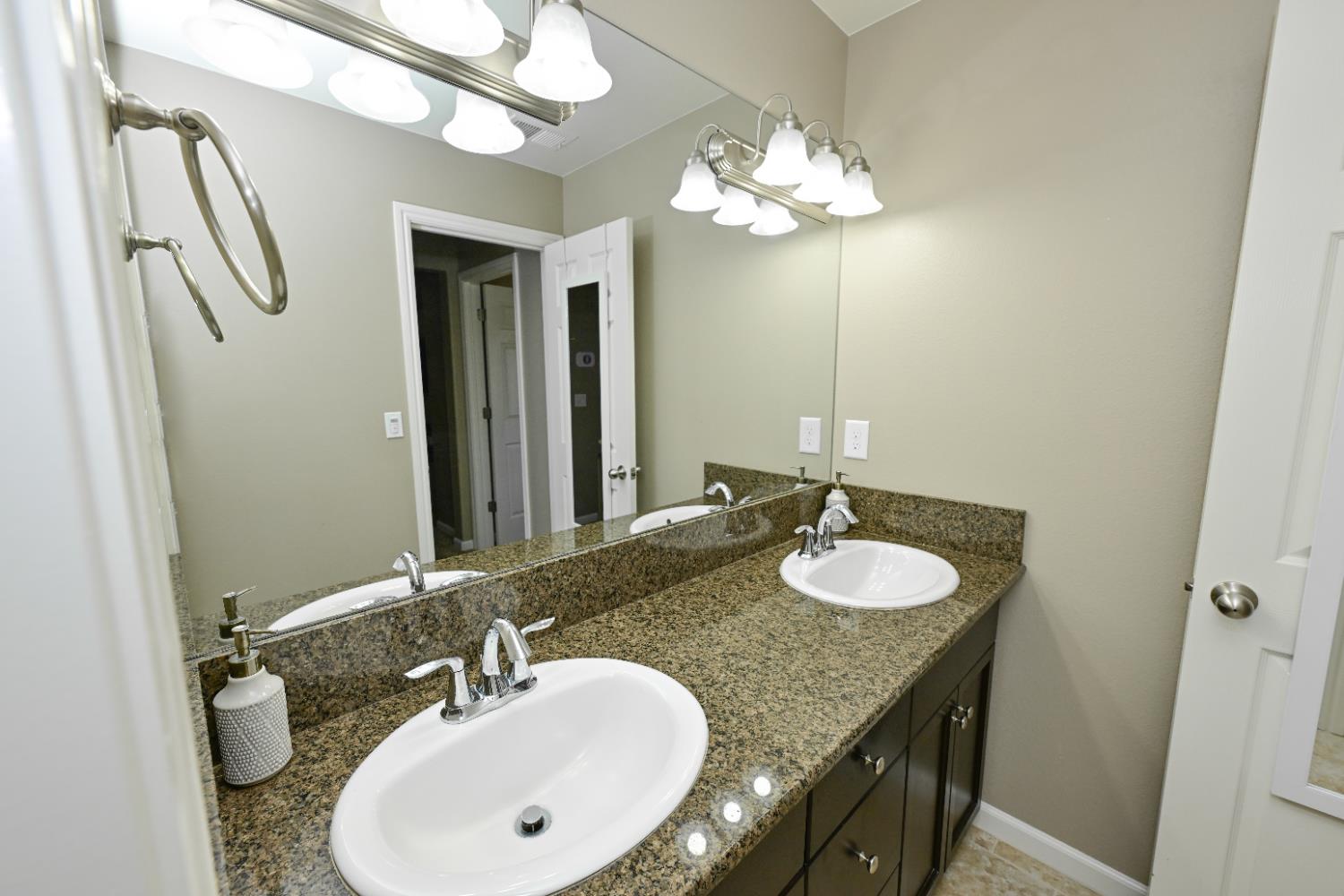 3569 Flint Avenue Clovis, CA 93619 - Photo 20 of 25 a bathroom with a granite countertop sink a large mirror and a shower
