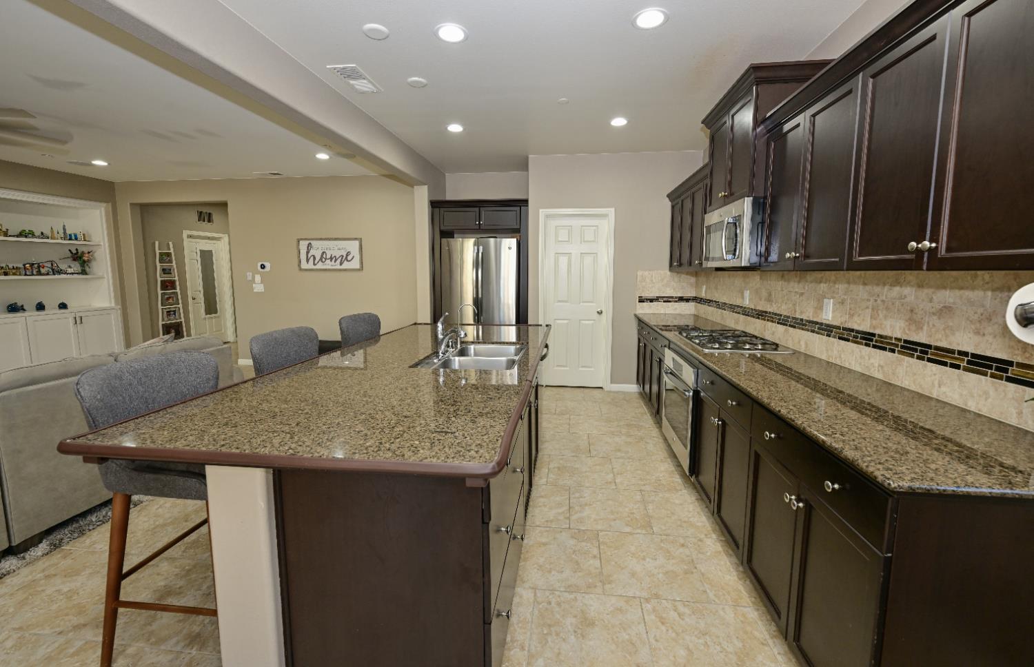 3569 Flint Avenue Clovis, CA 93619 - Photo 8 of 25 a large kitchen with stainless steel appliances granite countertop plenty wooden cabinets counter space and a sink