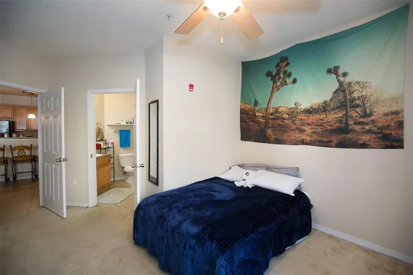 a bedroom with a bed and a painting on the wall