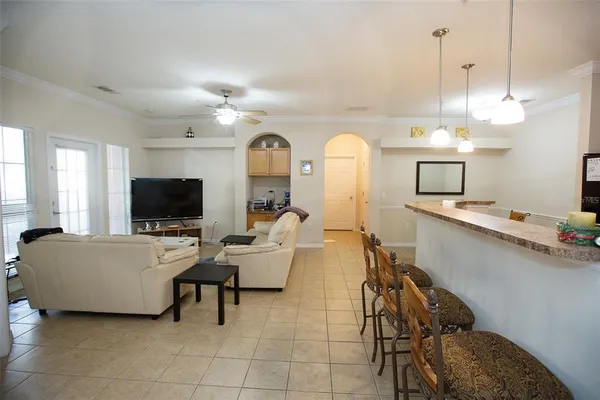 a living room with furniture a flat screen tv and a window