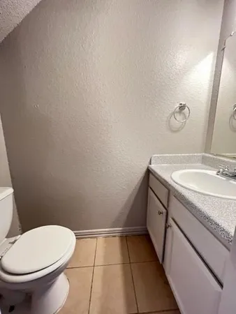 a bathroom with a granite countertop toilet and sink