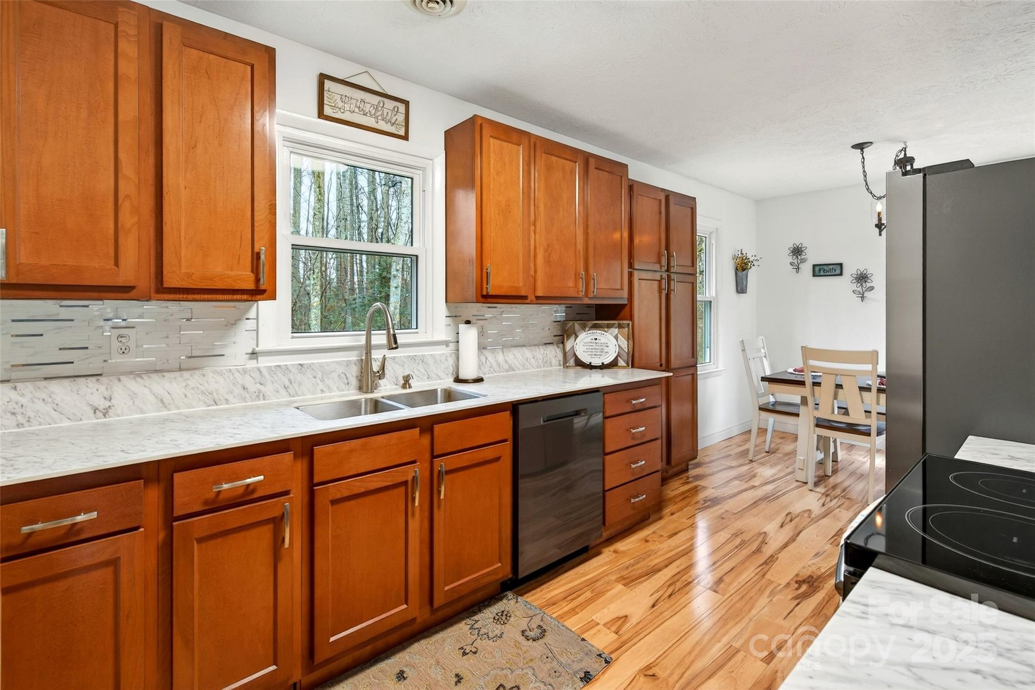 45 Due West Road Hendersonville, NC 28792 - Photo 11 of 45 a large kitchen with kitchen island granite countertop wooden cabinets a sink a window and stainless steel appliances