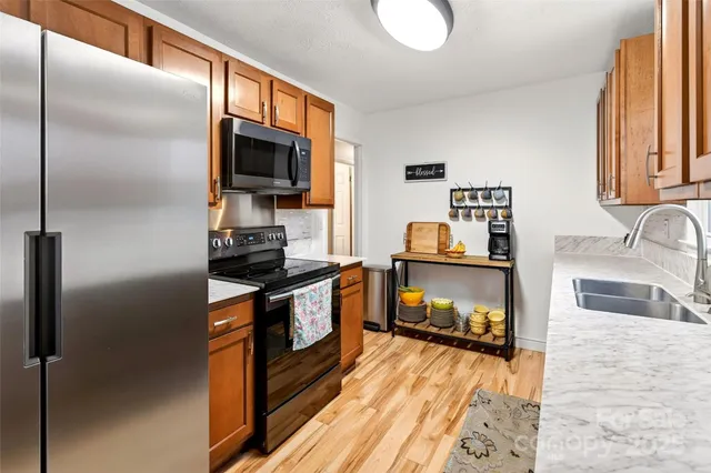 a kitchen with granite countertop a refrigerator stove and sink
