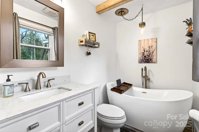 a bathroom with a granite countertop sink mirror vanity and toilet