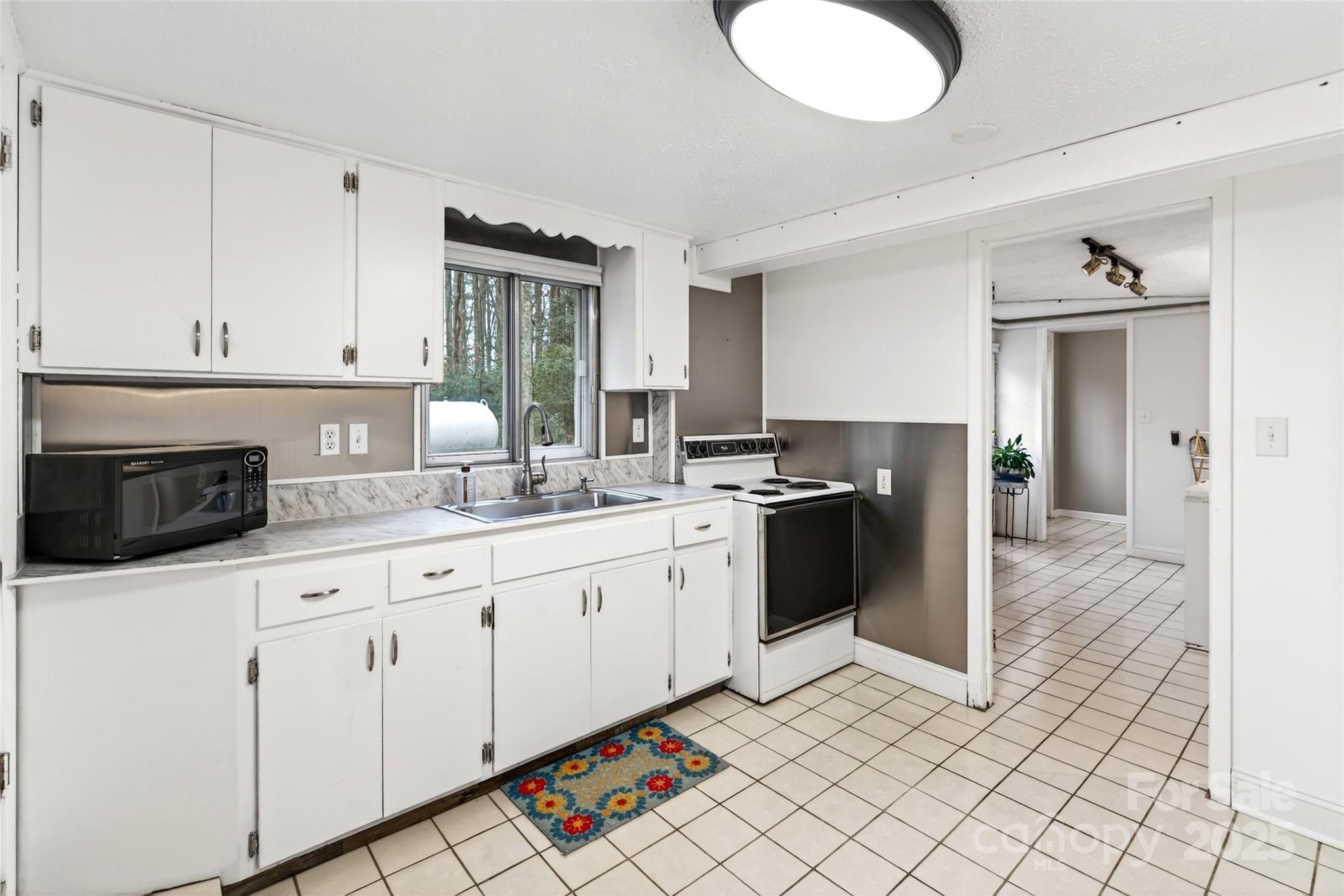 45 Due West Road Hendersonville, NC 28792 - Photo 27 of 45 a kitchen with granite countertop white cabinets and white appliances