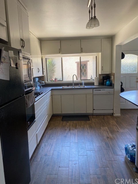 30772 Marilyn Drive Laguna Beach, CA 92651 - Photo 10 of 26 a kitchen with stainless steel appliances granite countertop a refrigerator a sink dishwasher a stove and white countertops with wooden floor
