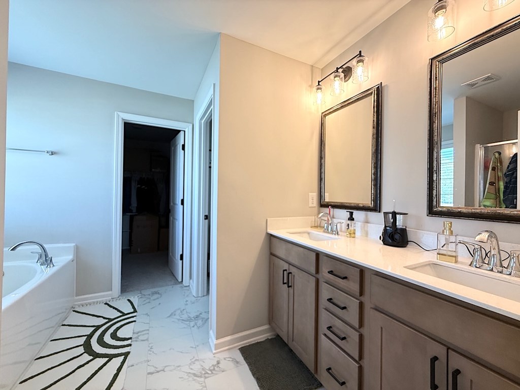 33 Sugar Maple Drive Fort Mitchell, AL 36856 - Photo 19 of 29 a spacious bathroom with a double vanity sink a mirror and a bathtub