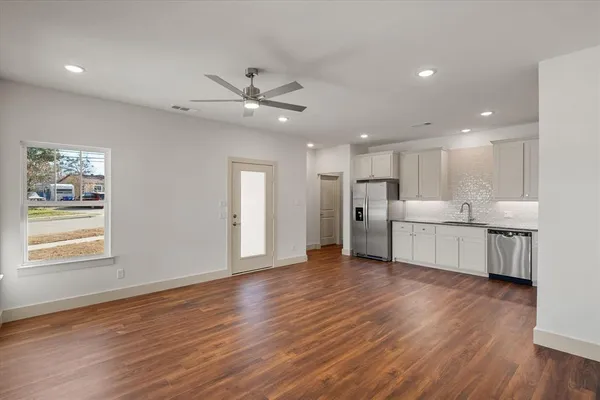 a view of a kitchen with furniture and wooden floor
