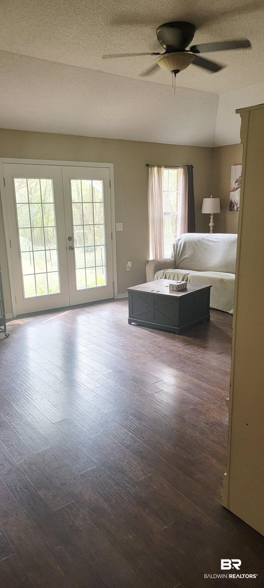 24590 Powell Road Loxley, AL 36551 - Photo 19 of 27 Living area with a textured ceiling, dark wood finished floors, ceiling fan, french doors, and vaulted ceiling