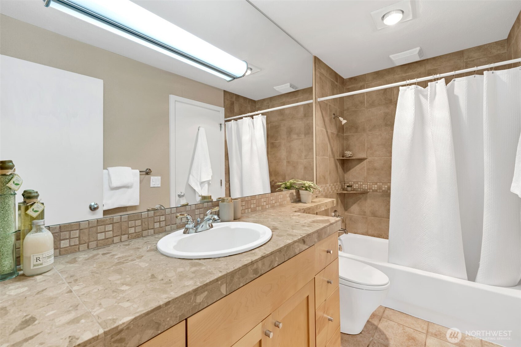275 West Roy Street, Unit 319 Seattle, WA 98119 - Photo 16 of 30 a bathroom with a sink toilet a mirror and shower
