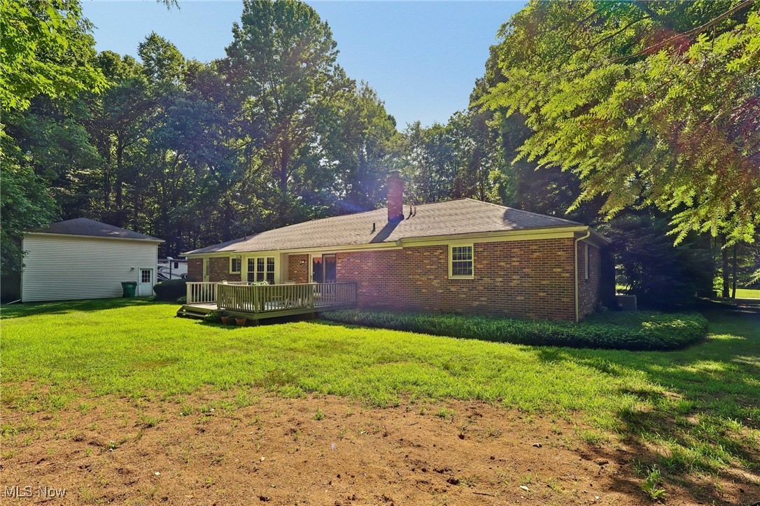 5568 Forest Glen Road Madison, OH 44057 - Photo 43 of 50 Back of property featuring brick siding, a deck, a yard, and a chimney