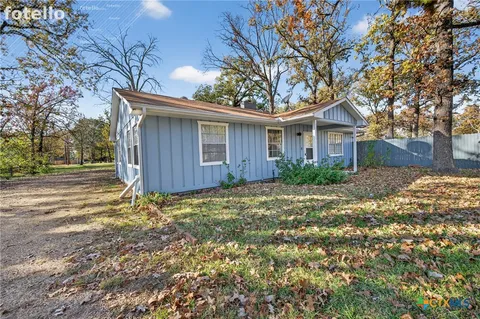 a front view of house with yard and trees around