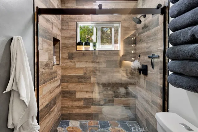 a bedroom with bed a flat tv screen and a large window with the garden view