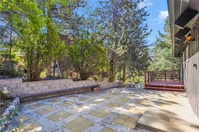 a living room with furniture a rug kitchen view and large windows