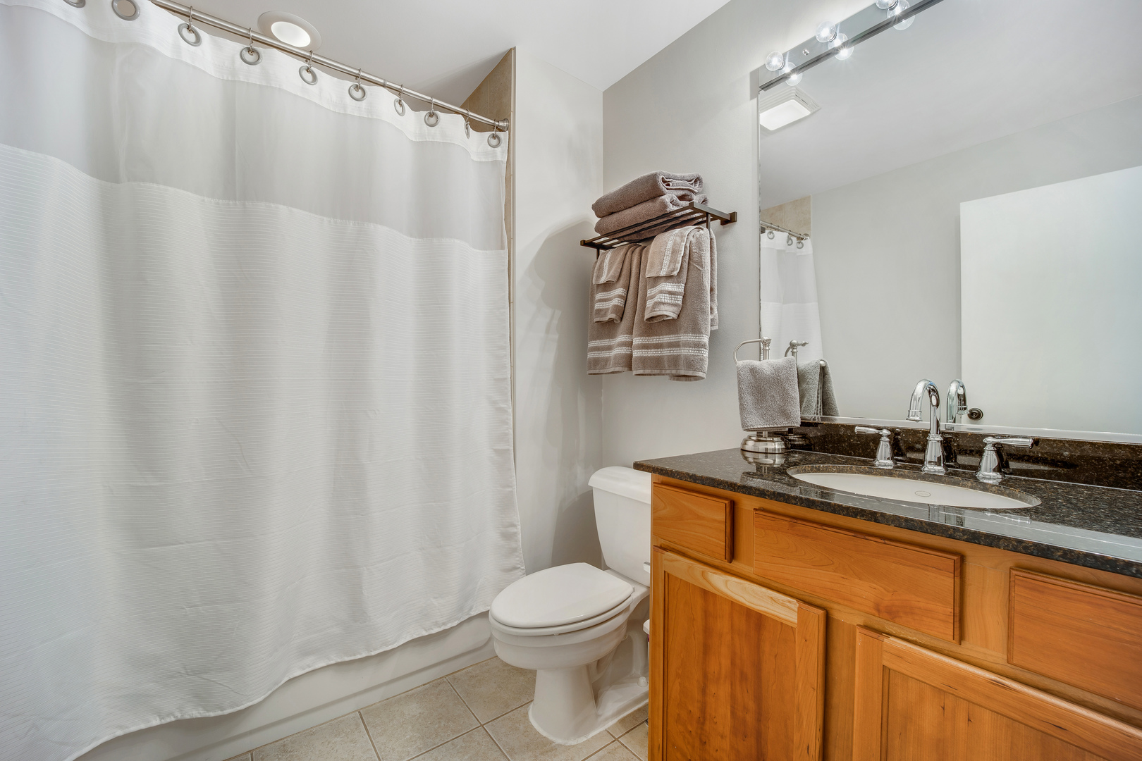 1111 West 15th Street, Unit 123 Chicago, IL 60608 - Photo 13 of 24 a bathroom with a granite countertop sink toilet and a mirror