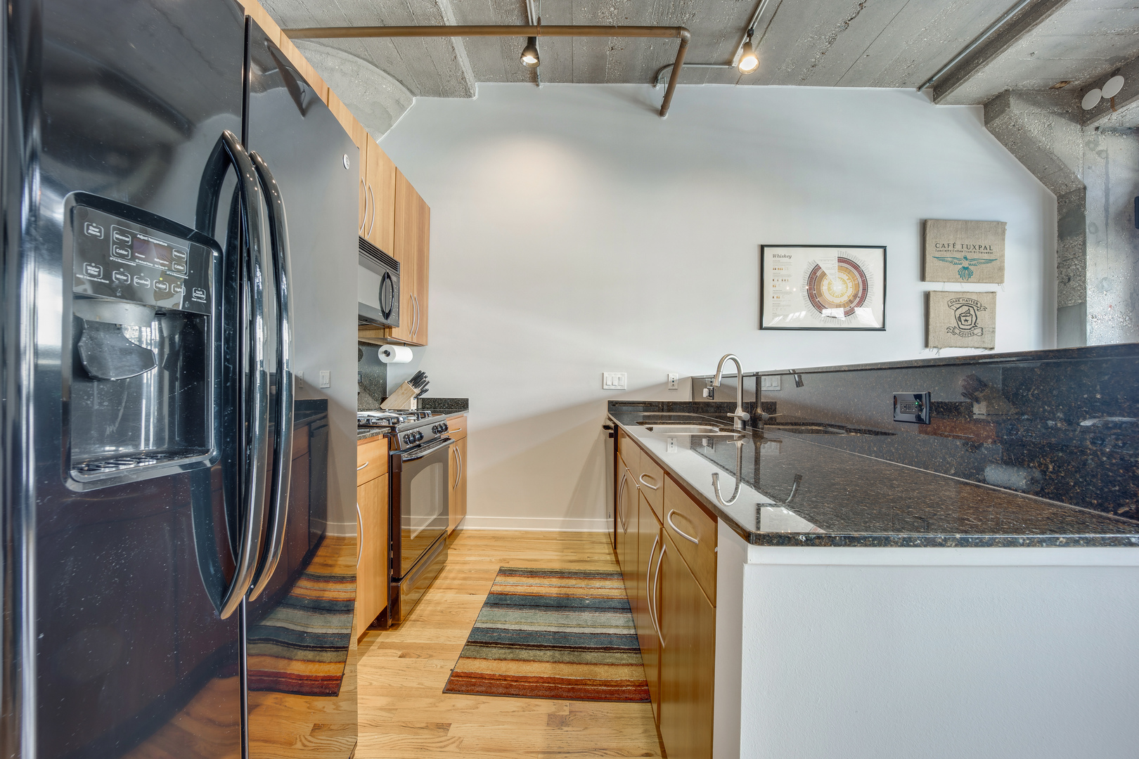 1111 West 15th Street, Unit 123 Chicago, IL 60608 - Photo 9 of 24 a kitchen with stainless steel appliances granite countertop a sink and a refrigerator