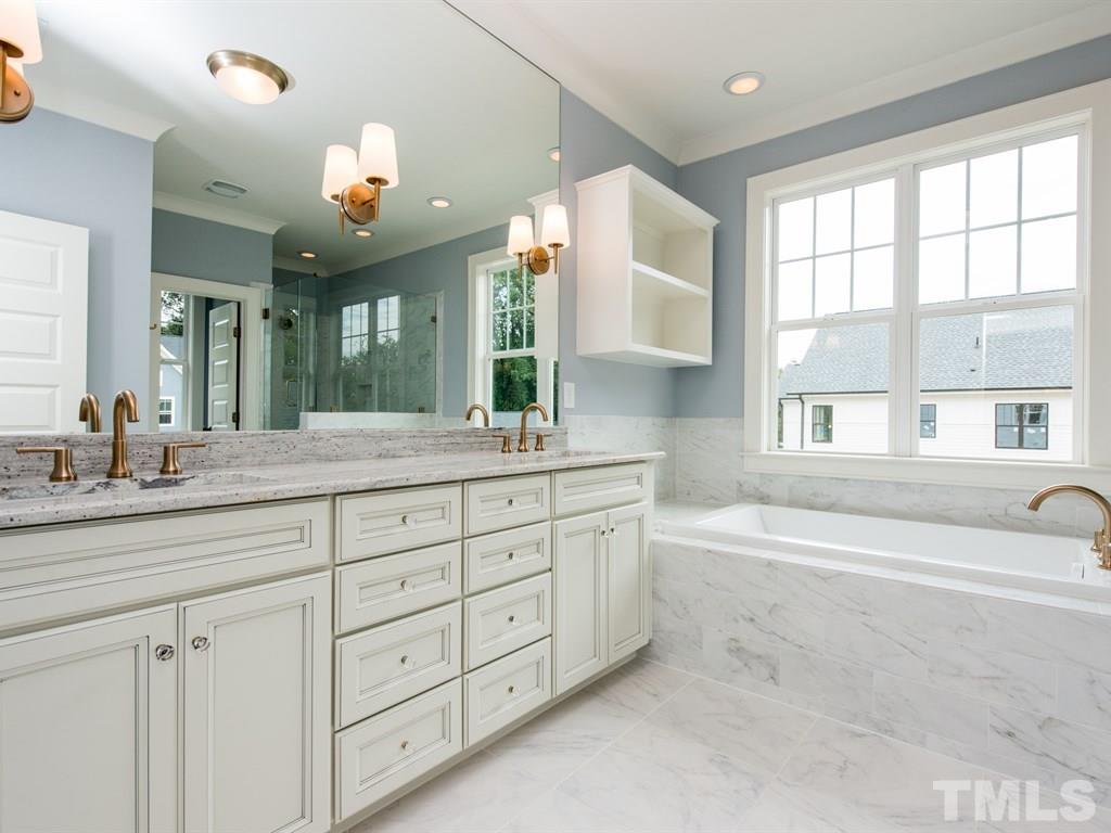 102 Revival Way Raleigh, NC 27608 - Photo 16 of 25 a spacious bathroom with a granite countertop sink mirror and a bathtub
