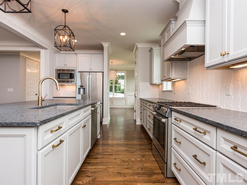 102 Revival Way Raleigh, NC 27608 - Photo 5 of 25 a kitchen with kitchen island granite countertop a sink and refrigerator